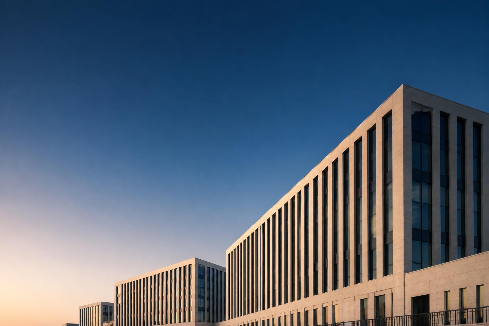 Restrained limestone and glass façade in the Luxembourg financial district at dawn